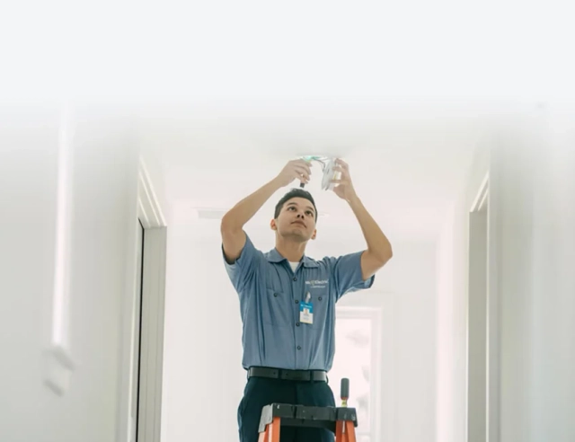 Seenyor technician fitting the sensor to a ceiling during a professional installation